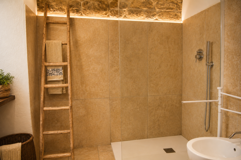 Bagno con doccia walk-in e materiali naturali - Pajara alle Macchie – Torre Vado, Salento Bagno di Pajara alle Macchie con doccia walk-in, scala in legno e muratura originale a vista.