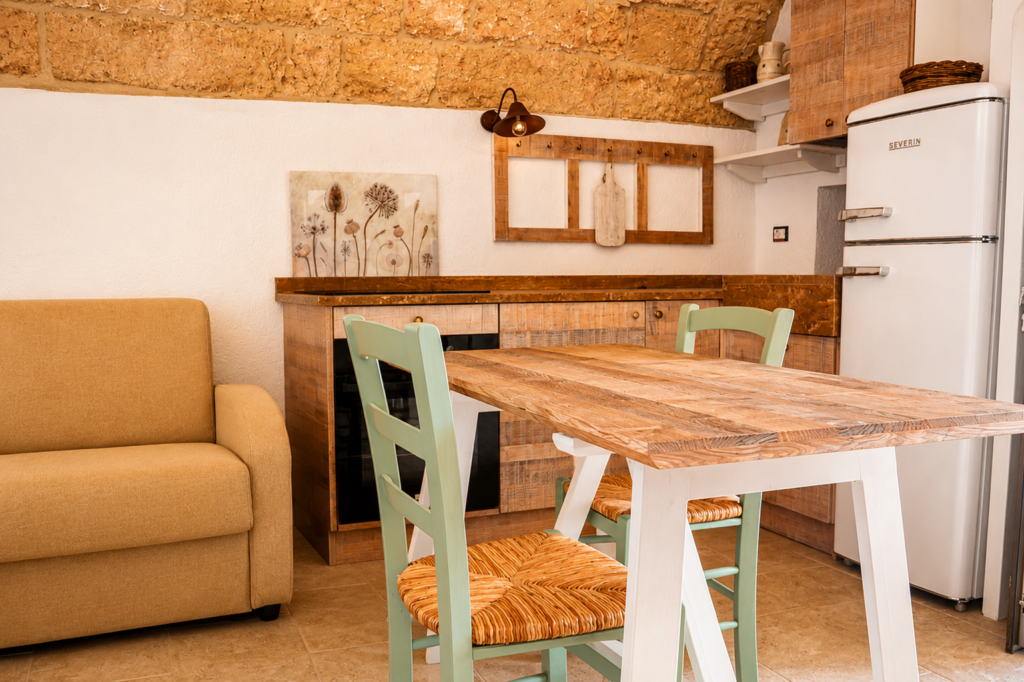 Interni della Liama – Cucina e zona giorno - Pajara alle Macchie – Torre Vado, Salento Interni della Liama di Pajara alle Macchie con cucina in legno, tavolo da pranzo e volta in pietra leccese originale.